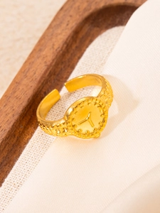 Detailed close-up of 18k gold-plated irregular geometric ring with vintage relief patterns