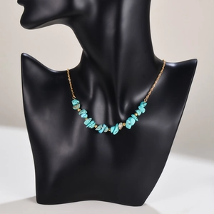 Handmade necklace with natural turquoise stone chips and golden beads on a black bust