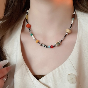 Close-up of bohemian beaded necklace with mixed colorful stone and wood beads on a model