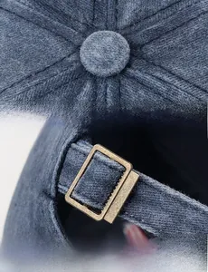 Close-up of adjustable bronze metal buckle and stitching on washed cotton baseball cap