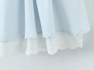 Détail de près du tissu à chevrons bleu clair avec bordure en dentelle fleurie blanche