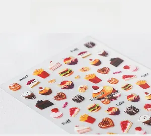 Detailed macro view of 5D dessert nail stickers featuring cupcakes and snacks