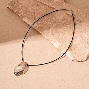 Detailed view of silver irregular heart pendant with smooth liquid metal texture on cord