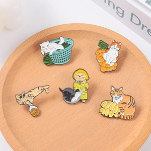 Set of five creative cat enamel pins on a wooden tray featuring colorful feline designs