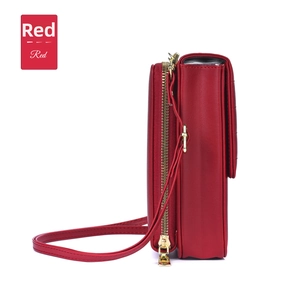 Detail view of red leather crossbody phone bag featuring a double-layer compartment