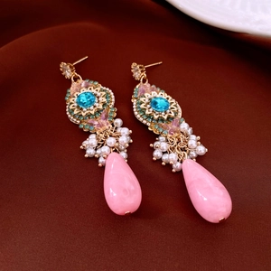 Detailed close-up of bohemian drop earrings with blue stone and pink teardrop beads