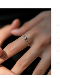 Macro shot of s925 silver beaded ring with heart-shaped moissanite stone on finger