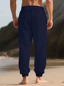 Détail du pantalon en maille jacquard bleu marine avec ourlet côtelé et taille à cordon