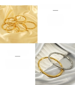 Détail de bracelets en acier inoxydable doré et argenté avec des perles tubulaires lisses