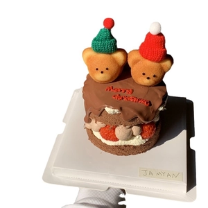 Christmas cake with teddy bears wearing knitted hats and fresh strawberries