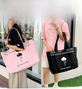 Detailed view of spacious canvas tote bags in pink and black with floral art prints