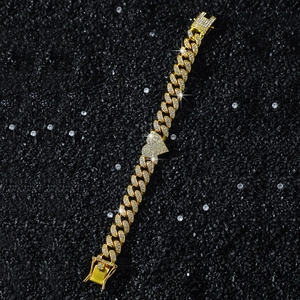 Close-up of 13mm gold Cuban link bracelet with iced-out heart pendant on black background