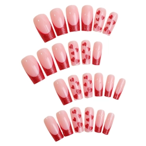 Long coffin fake nails with nude base, red glitter French tips and heart design