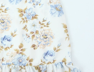 Nahaufnahme von Vintage-Blumenmuster-Stoff mit Rüschensaum an einem schmalen Kleid