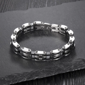 Macro detail of industrial style stainless steel chain bracelet on natural stone surface