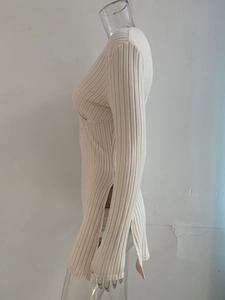 Detail shot of beige ribbed knit texture with a stylish side slit design for women