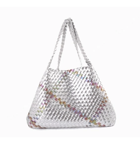 Detail of silver hand-woven tote bag showing metallic texture and colorful geometric patterns