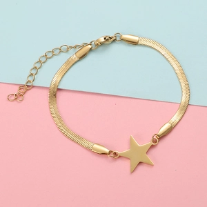 Close-up of gold stainless steel snake chain bracelet with star charm on geometric background