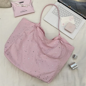 Close-up of pink canvas tote bag with shiny silver star prints and fabric handles