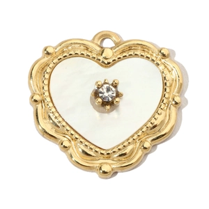 Macro view of a gold-framed heart pendant with white shell inlay and center rhinestone