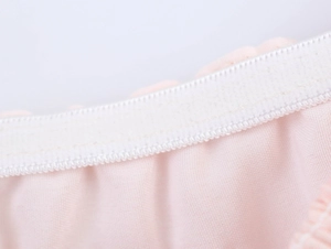 Dettaglio del tessuto rosa con elastico a punto smock e trama a maglia fine