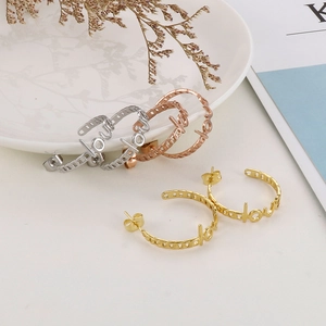 Detail of three-color LOVE letter hoop earrings with hollow chain design in gold and silver