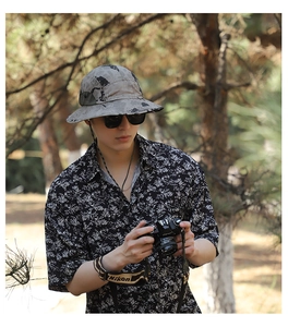 Outdoor camouflage bucket hat detail worn with floral shirt in forest nature setting