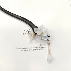 Detail of wooden hair stick with white magnolia flower, gold tassels and pearls