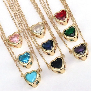 Dettaglio di pendenti in zirconia colorata a forma di cuore su collane dorate in nove colori vivaci