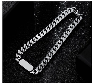 Detailed view of silver titanium steel Cuban link ID bracelet on black textured background