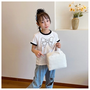 Detailed view of white canvas insulated lunch bag carried by a child model outdoors