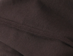 Vue macro de la texture du tricot côtelé marron foncé et détails de couture de qualité