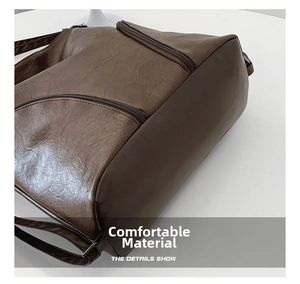 Detail of dark brown PU leather backpack side showing smooth metal zipper and soft texture