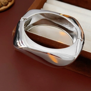 Close-up of polished silver irregular open cuff bracelet on a luxury jewelry box