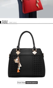 Detail of classic black tote bag featuring rhombus pattern and gold flower tassel charm