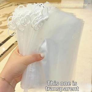 Close-up of stacked clear plastic storage bags with white ring pull zippers and hand detail