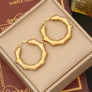 Elegant gold bamboo hoop earrings with textured finish in a luxury jewelry box