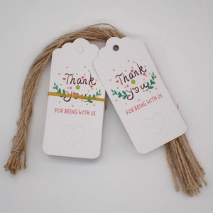 Detailed view of white paper gift tags with Thank You text and natural jute twine strings