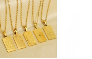 Macro detail of 18K gold stainless steel tarot pendants featuring sun and moon carvings