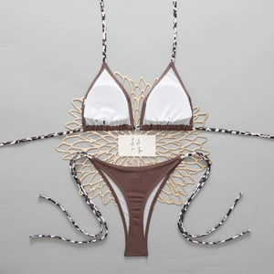 Flat lay of brown bikini with leopard print ties and decorative gold floral coasters