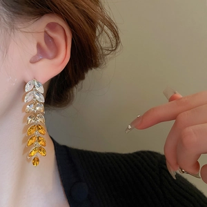 Macro view of gradient leaf tassel earrings with sparkling crystals for elegant style
