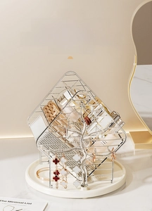 Close-up of a silver rotating makeup organizer with diamond mesh and branch hook detail