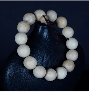 Macro detail of natural camphor wood beads showing smooth matte texture and grain