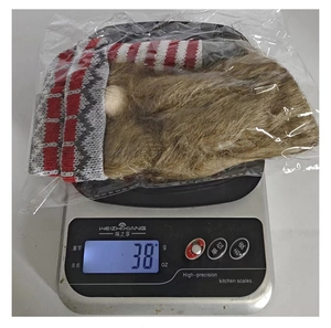 Weight measurement of 38g for the knitted Santa wine bottle cover in clear packaging