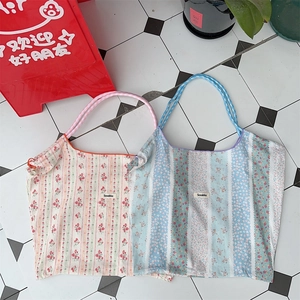 Close-up of floral stripe canvas tote bags set in pink and blue with brand label