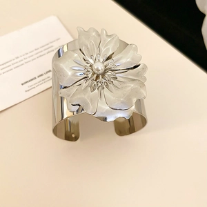 Detail of silver metallic flower cuff bracelet with layered petals and center pearl