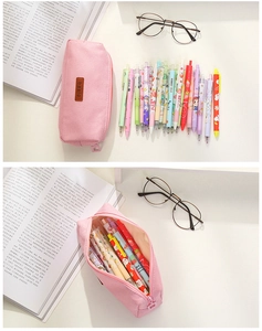 Detail showing high-capacity pink canvas stationery bag with zipper and office supplies