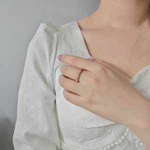 Close-up of rose gold ring featuring micro-paved cubic zirconia in a triple-row design