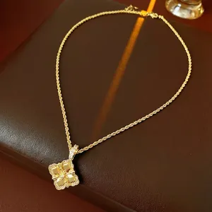 Élégant collier doré avec pendentif fleur serti de diamants sur socle en cuir