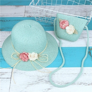 Détail d'un chapeau de paille vert menthe pour enfant et sac bandoulière assorti à fleurs